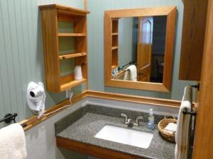 Quartz countertop sinks. The shelf units and mirror frames were made from reclaimed longleaf pine.